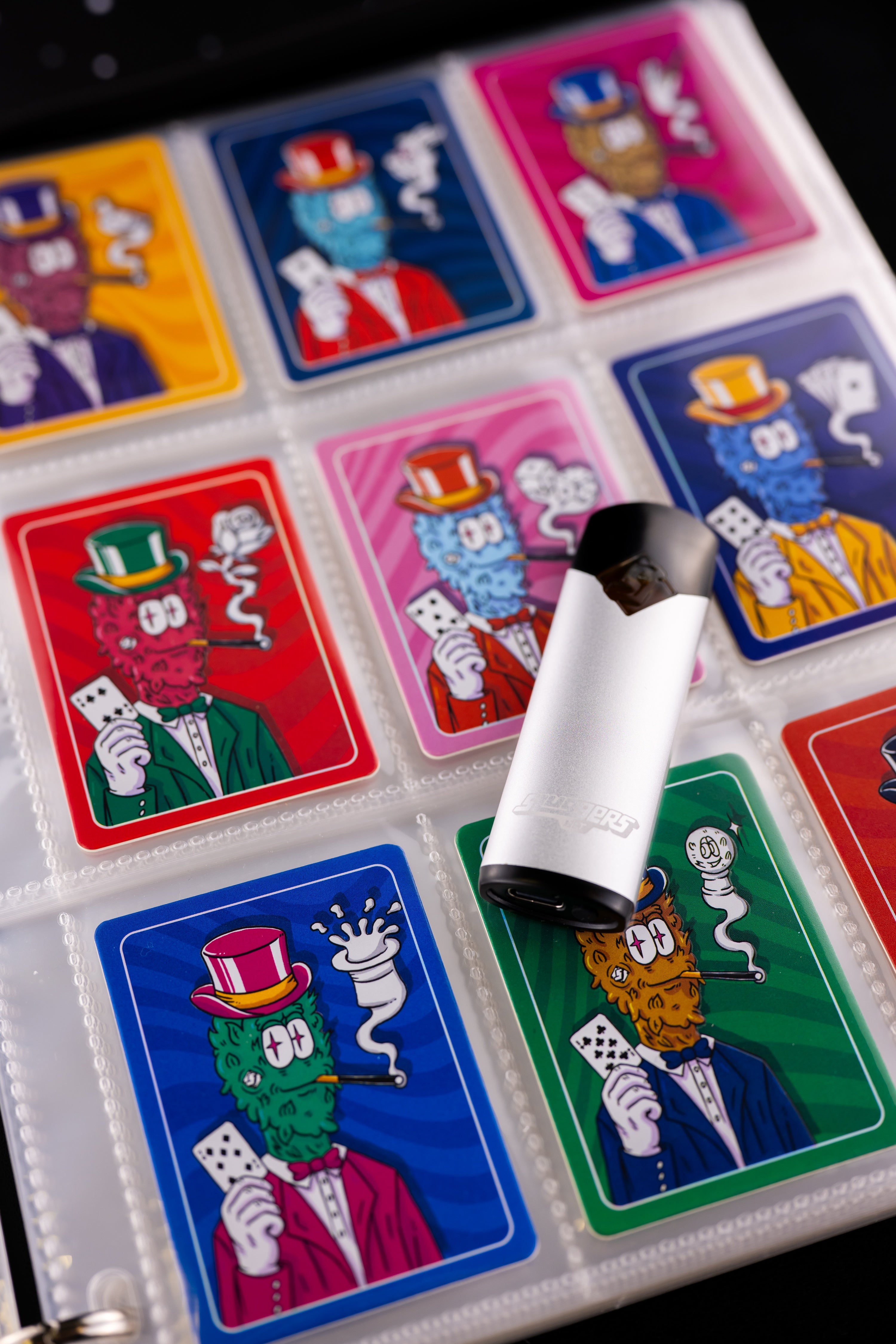 Close view of a rosin vape resting on a binder of assorted Sluggers collectible cards. Included card is random.